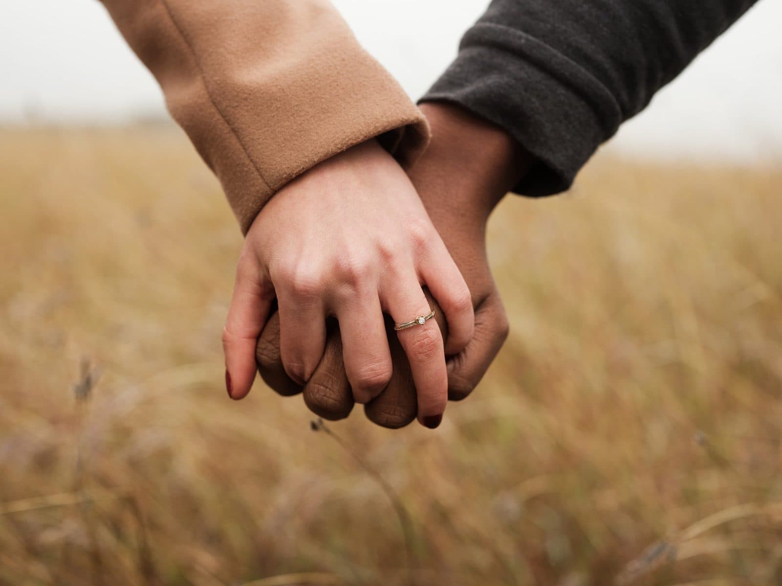 Two hands clasped outdoors